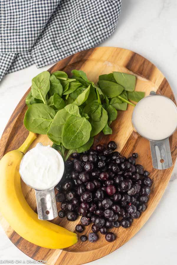 Overview of the ingredients to make the smoothie: spinach, blueberry, milk, yogurt and banana.  