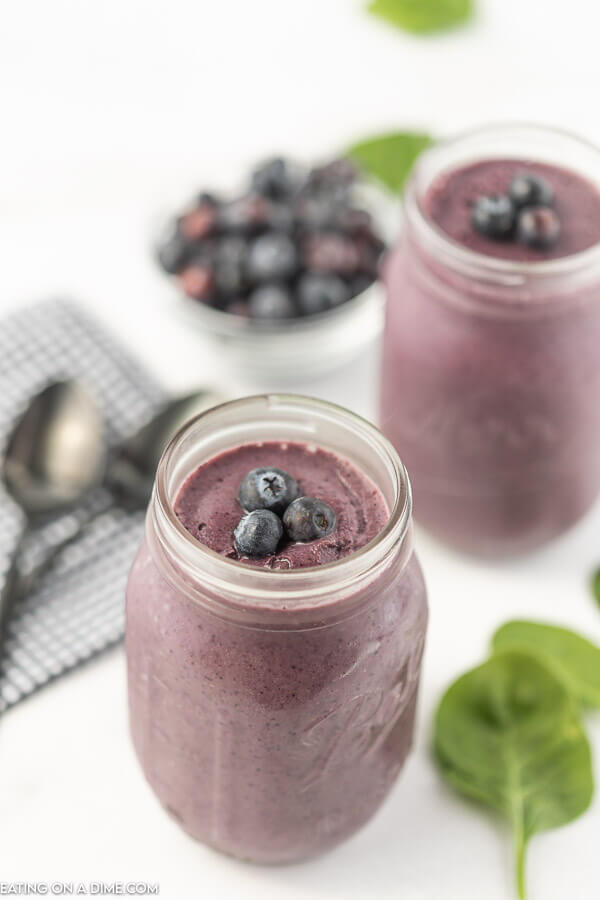 Overview of a blueberry spinach smoothie with a 2nd smoothie in the background.  