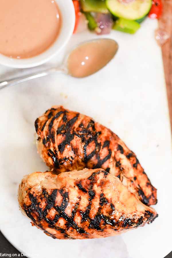 Grilled Chicken Breast on a plate with a bowl of the bbq sauce and ranch 