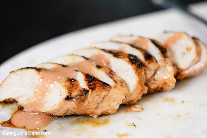 Grilled Chicken Breast on a plate sliced with the BBQ and Ranch Sauce drizzled over the top