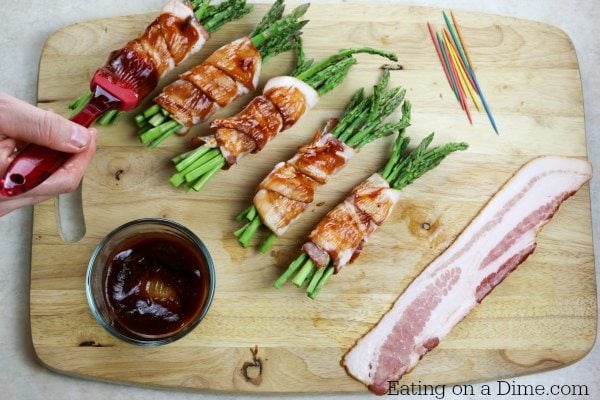 Basting the bacon wrapped asparagus with BBQ Sauce