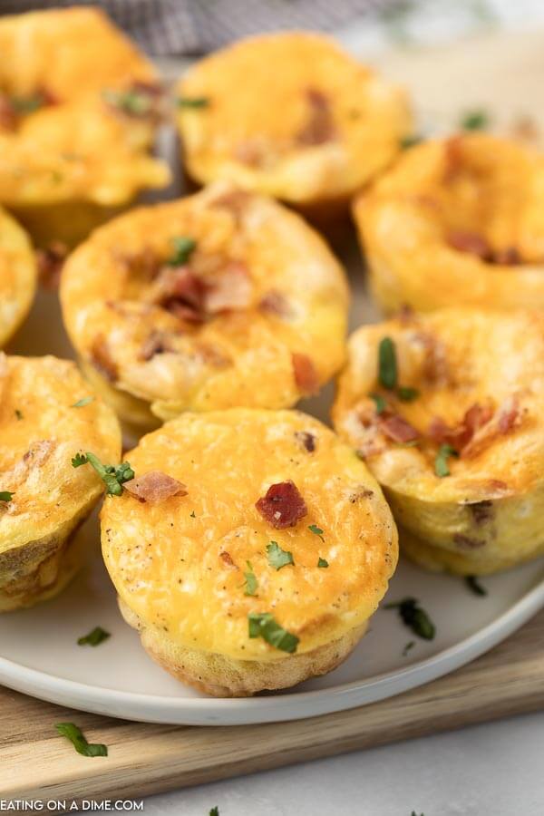 Close up of egg muffins on a white plate topped with fresh parsley 