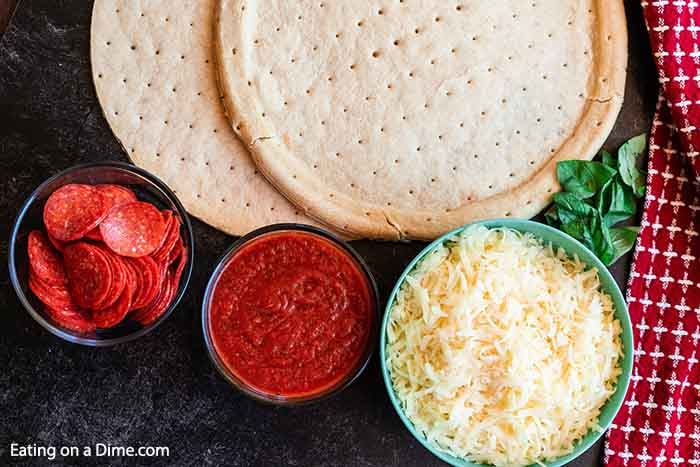 Ingredients for Grilled Pizza - Pizza Crust, Pizza Sauce, Cheese, pepperoni, basil leaves