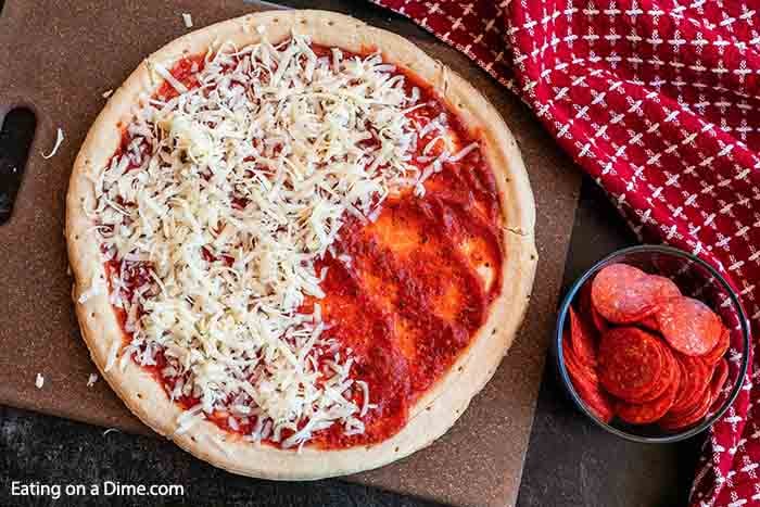 Topping the pizza with shredded cheese 