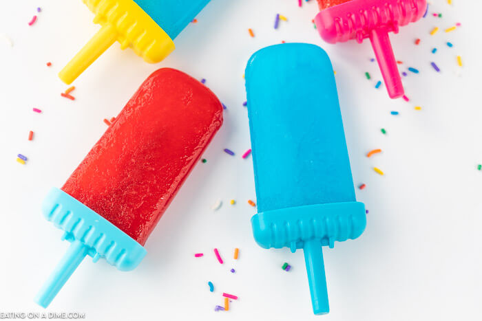 homemade no-drip popsicles on a white board with sprinkles scattered around them 