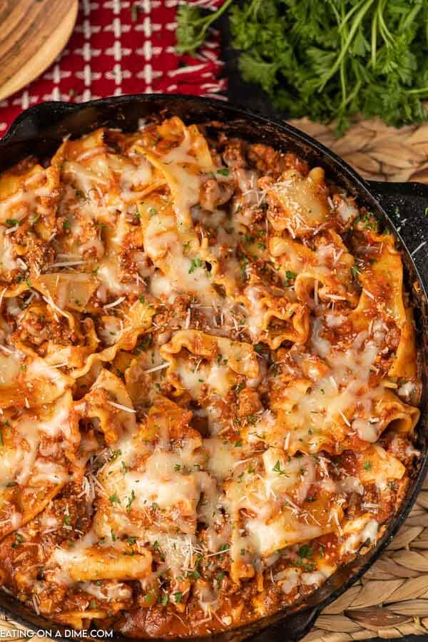 Skillet lasagna topped with shredded parmesan cheese and chopped fresh parsley 