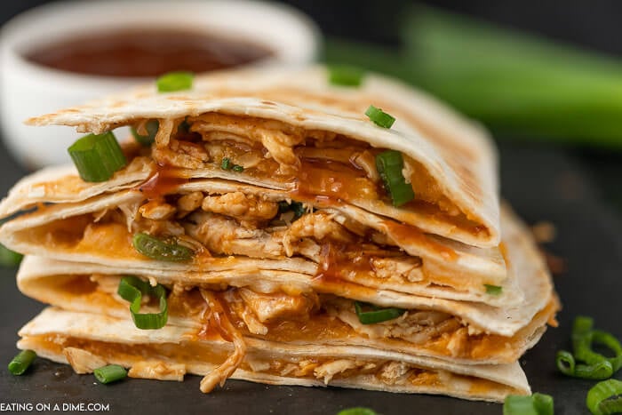 BBQ Chicken Quesadilla with green onions on a black platter 
