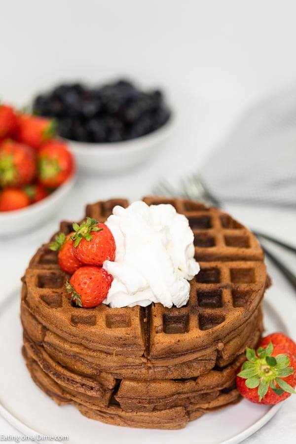Chocolate Cake Mix Waffles topped with whipped cream and fresh strawberries