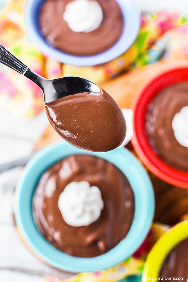 Chocolate pudding in bowls with a bite on a spoon