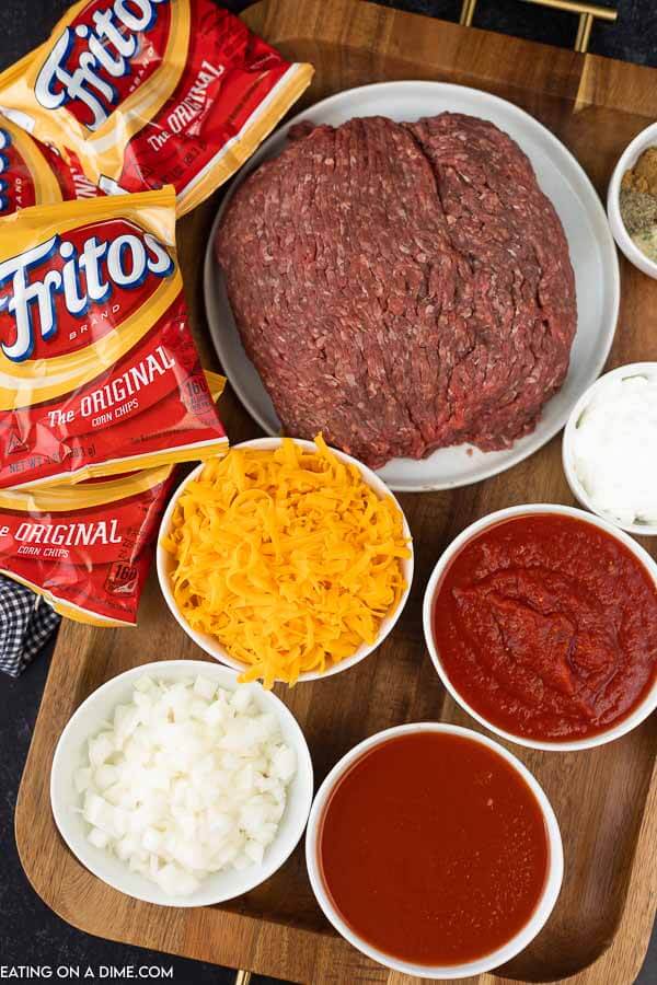 picture of ingredients - bags of Fritos, ground beef, tomato sauce, broth, seasonings and toppings.