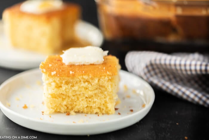 Close up image of a piece of cornbread with butter on top. 