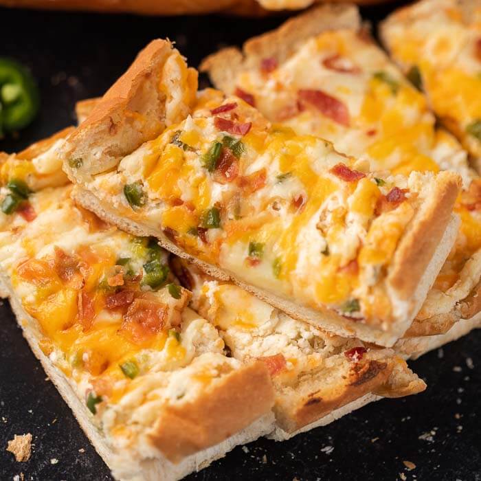 Jalapeno popper stuffed cheesy bread recipe is the perfect appetizer and also delicious with a meal. Each bite is so cheesy and delicious.