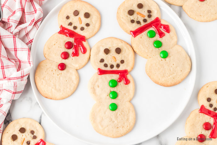 Close up image of snowman sugar cookies on a white plate. 
