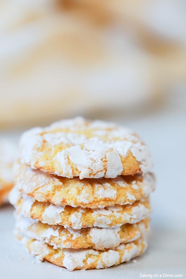 Close up of multiple lemon crinkle cookies stacked on top of each other. 