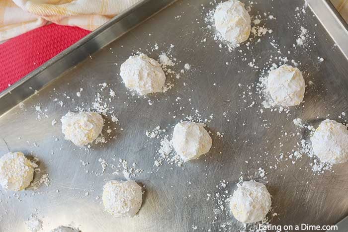 The cookie dough coated in powdered sugar and placed on a baking sheet. 
