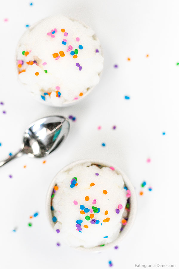 Close up image of two white bowls of snow ice cream with sprinkles and a silver spoon. 