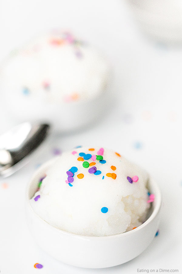 Close up image of snow ice cream in a white bowl with sprinkles on top.