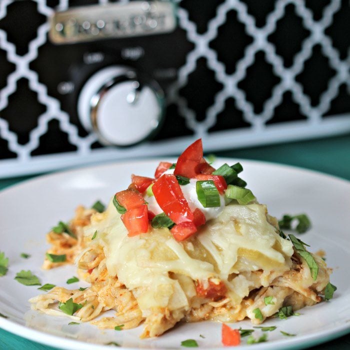 If you love easy recipes like I do, Try this super easy Crock Pot Chicken Enchilada Casserole Recipe. Your favorite healthy enchilada recipe layered and cooked in a crock pot! You'll love this easy Mexican meal with corn tortillas and green enchilada sauce. #eatingonadime #mexicanrecipes #dinnerrecipes #enchiladarecipes Chicken Enchilada on a plate