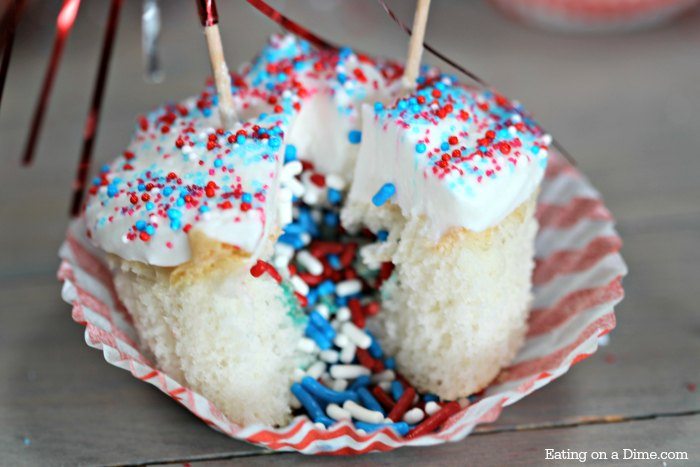 Cupcakes topped with red white and blue sprinkles and a American flag cut with sprinkles coming out of the cupcake