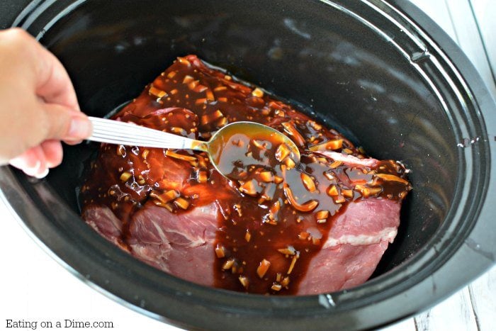 Pouring the sauce on the ribs in the slow cooker