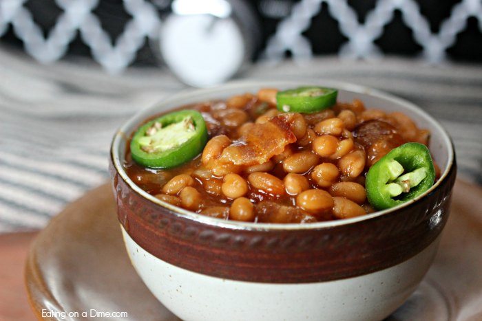 Close up image of a bowl of baked beans with bacon and sliced jalapeno's