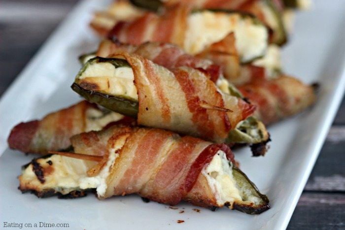 You have to try Bacon wrapped jalapeno poppers with only 3 ingredients, peppers, cream cheese and bacon! These grilled bacon wrapped stuffed jalapeño poppers are easy to make and packed with flavor. Bacon wrapped cream cheese jalapeños are the perfect snack or appetizer for the holidays or any party! The entire family loves these bacon wrapped jalapeño peppers. #eatingonadime #appetizers #jalapeñopoppers #easyappetizers 
