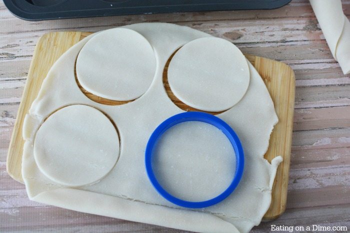 A circle cutter cutting out circles from the pie crusts 