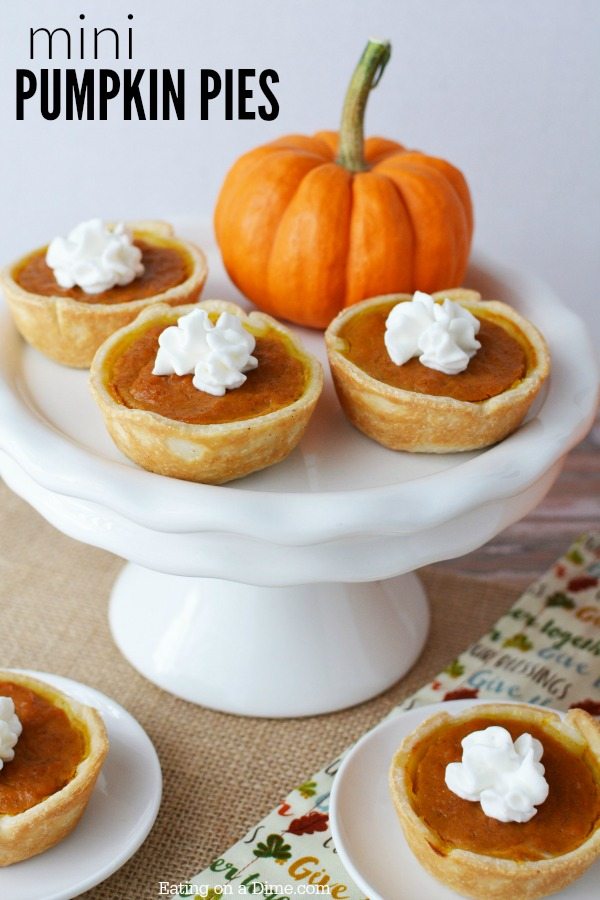 Mini Pumpkin Pies on a cake stand with a pumpkin next to it. 