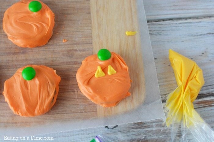 cookies dipped in orange candy melts ready for the face