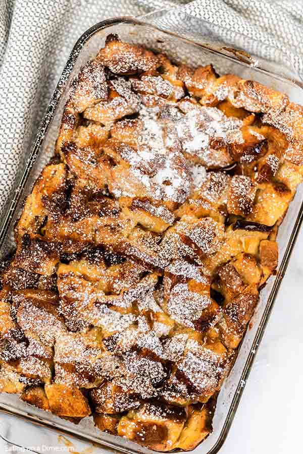 Close up image of french toast casserole in a 9x13 pan with powdered sugar on top. 