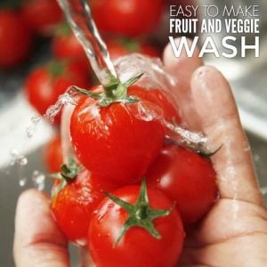 A hand holds several red tomatoes under running water, with a text overlay that reads, "Easy to make fruit and vegetable wash.