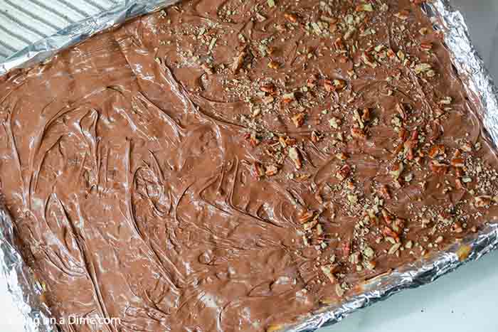 Close up image of saltine cracker toffee with chocolate on top with half of being topped with nuts. 