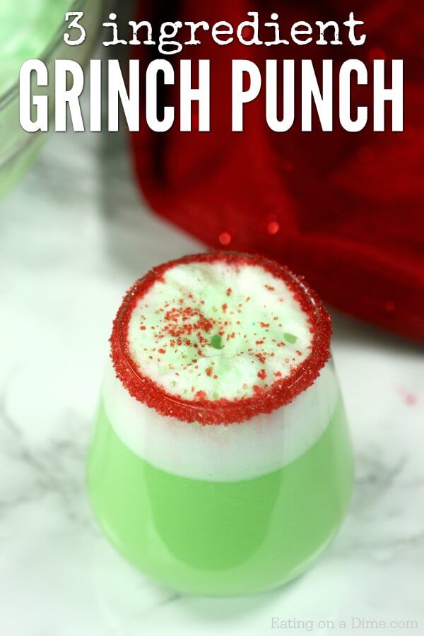 Close up image of decorative glass with red sprinkles of Grinch punch. 