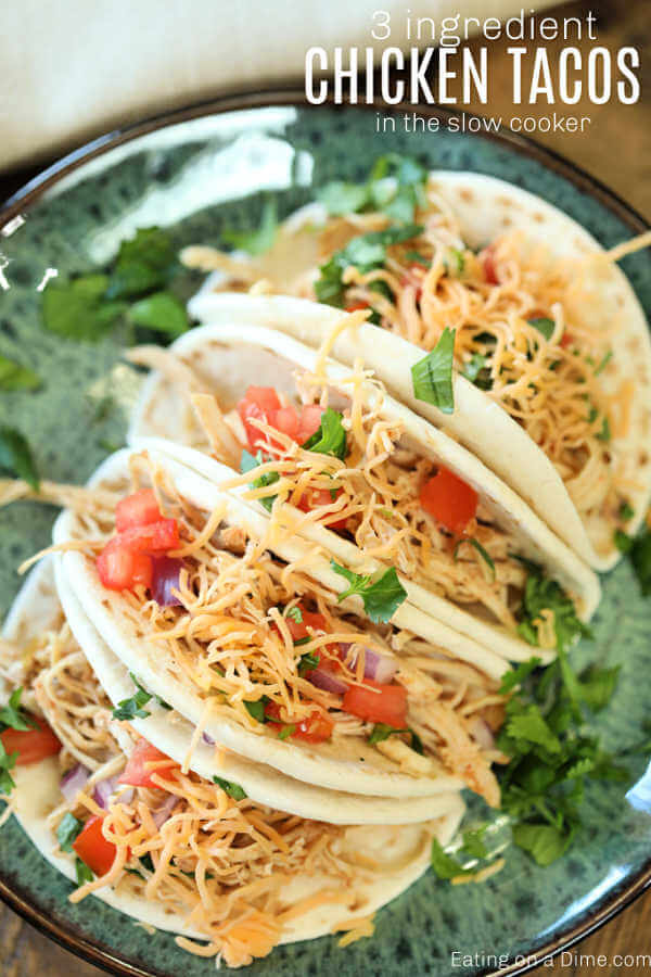 Chicken Tacos on a plate topped with tomatoes, cheese and lettuce