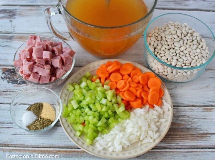 ingredients for instant pot ham and bean soup - white bean, ham, chicken broth, carrots, celery, onion, garlic powder, salt, italian seasoning, pepper, bay leaves