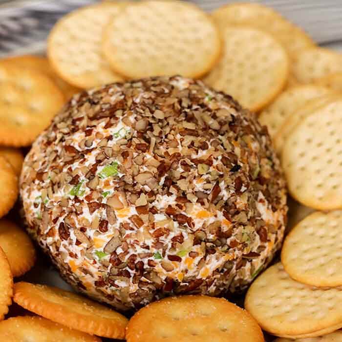 Close up image of Garlic Onion Cheese ball with a side of crackers. 