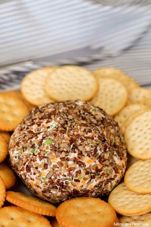 Close up image of a Garlic Onion Cheese ball with a side of crackers. 