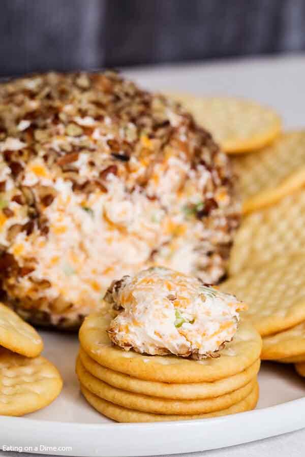 Close up image of Garlic Onion Cheese ball with a servin on a cracker. 