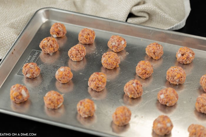 Image of sausage balls on a cookie sheet. 