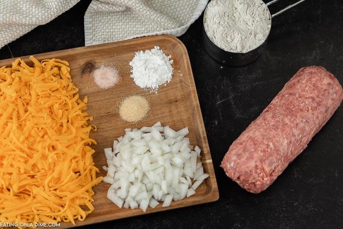Close up image of ingredients for sausage balls. It includes sausage, flour, onion, spices and cheese. 