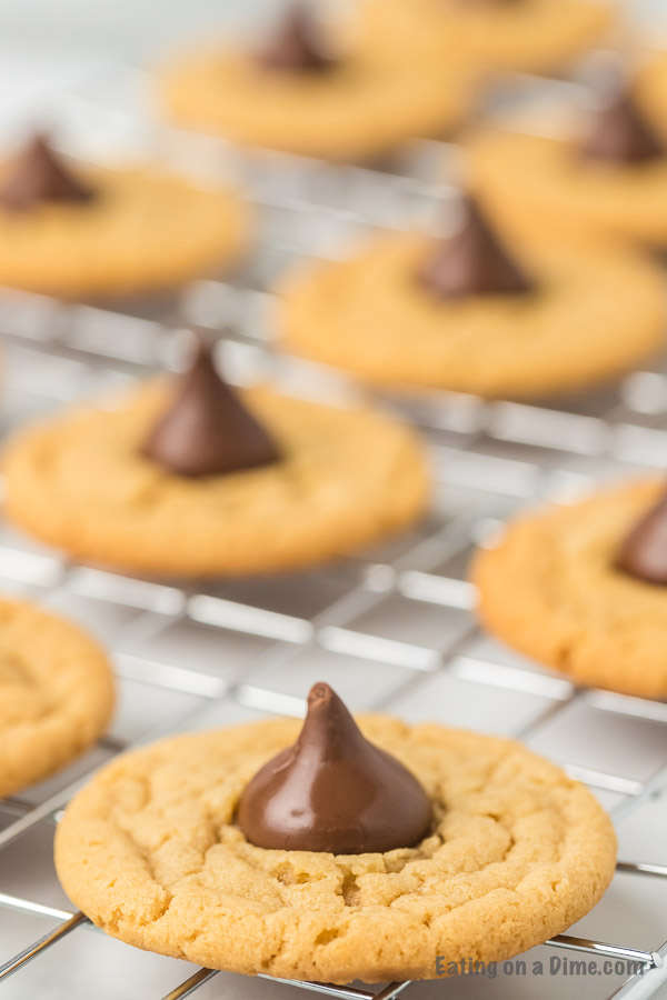Close up image a gluten free peanut butter kiss cookies on a cooling rack. 