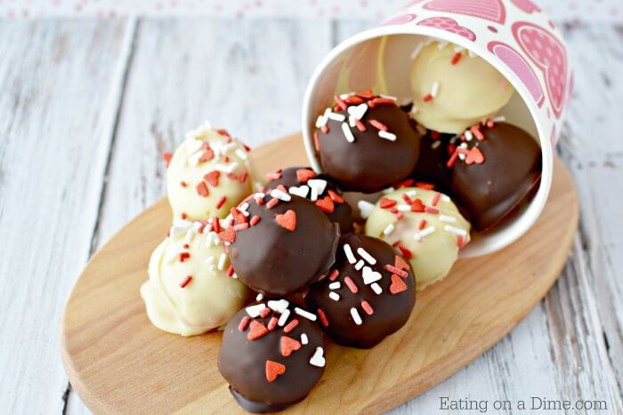 White Chocolate and Milk Chocolate covered cake balls falling out of a Valentine's Day cup.  