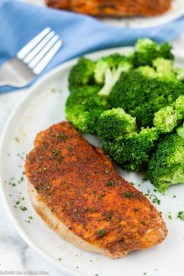 baked pork chop on white plate with broccoli
