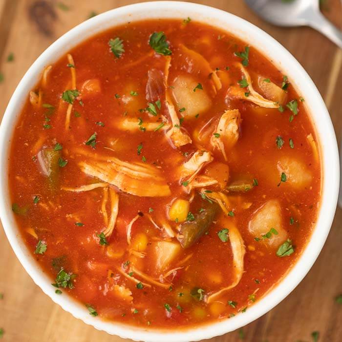 Closeup image of chicken vegetable soup in a white bowl. 