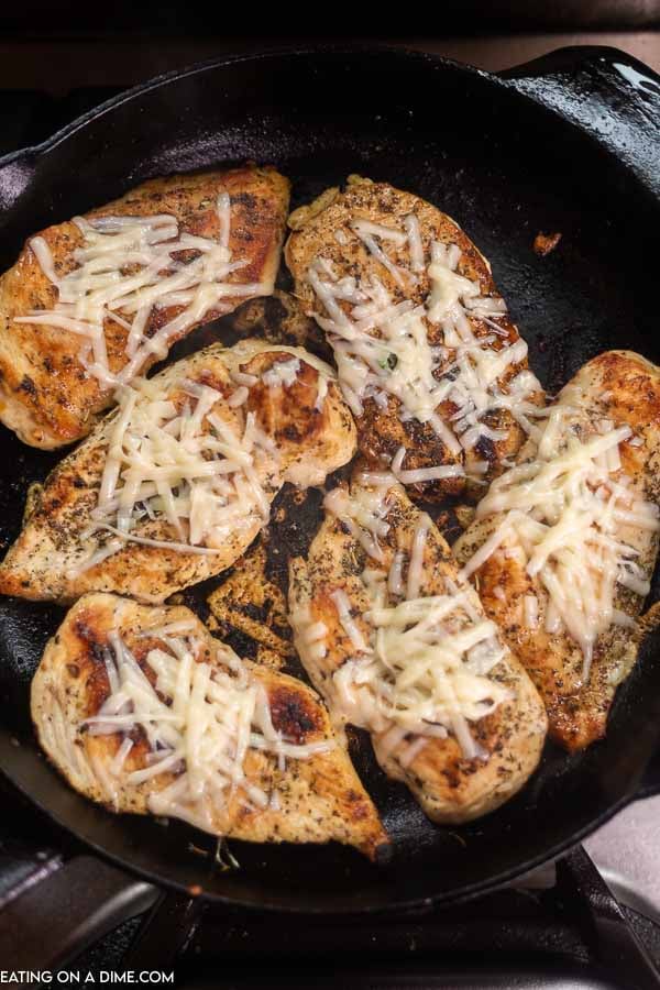 browned chicken topped with cheese in skillet