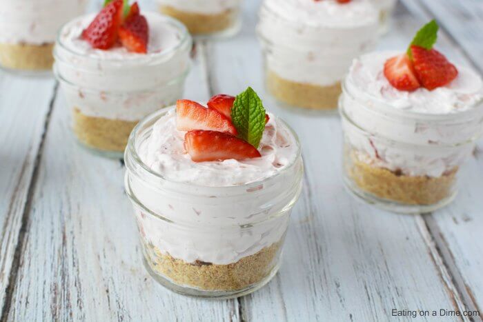 Cloe up image of cheesecake in a jar topped with strawberries. 