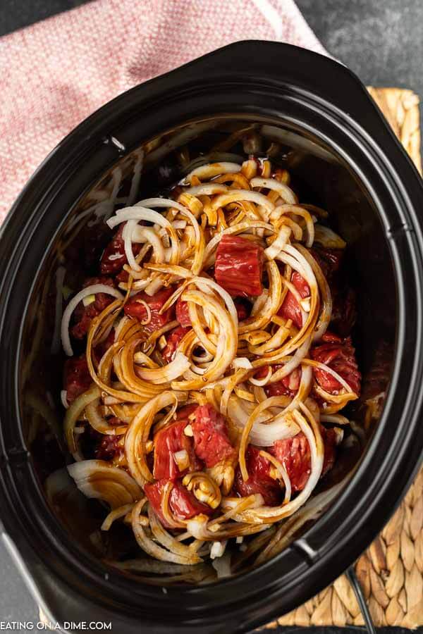 beef, onion, and teriyaki in the crock pot for crock pot beef teriyaki