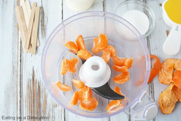 Oranges being placed in the food processor