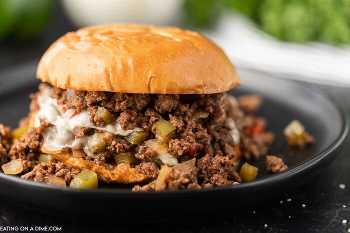 Philly Cheesesteak Sloppy Joes on a black plate with the mixture falling off of the bun! 