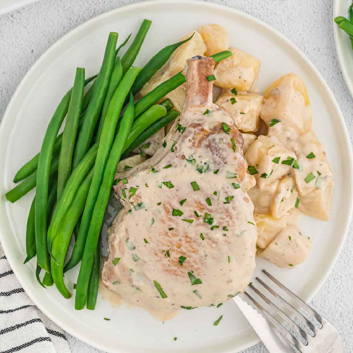 Cowboy pork chops with potatoes and green beans on a plate